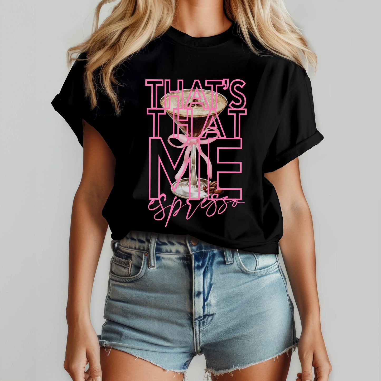 Woman wearing a black graphic t-shirt with bold pink text that reads "That’s That Me Espresso" featuring an espresso martini glass; inspired by Sabrina Carpenter’s hit song.