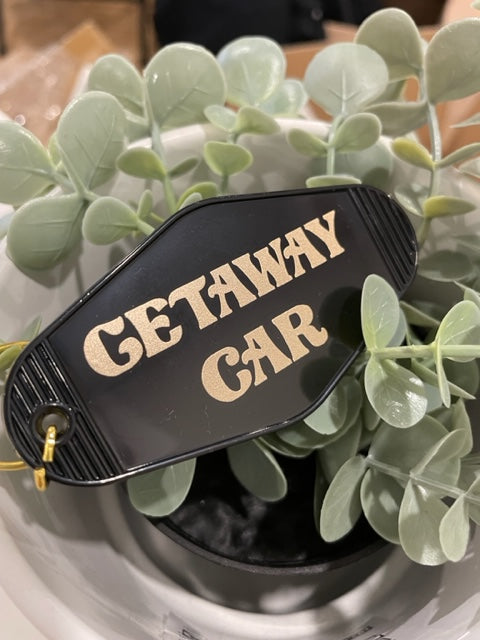 Black retro motel-style keychain with Getaway Car text in cream lettering inspired by Taylor Swift
