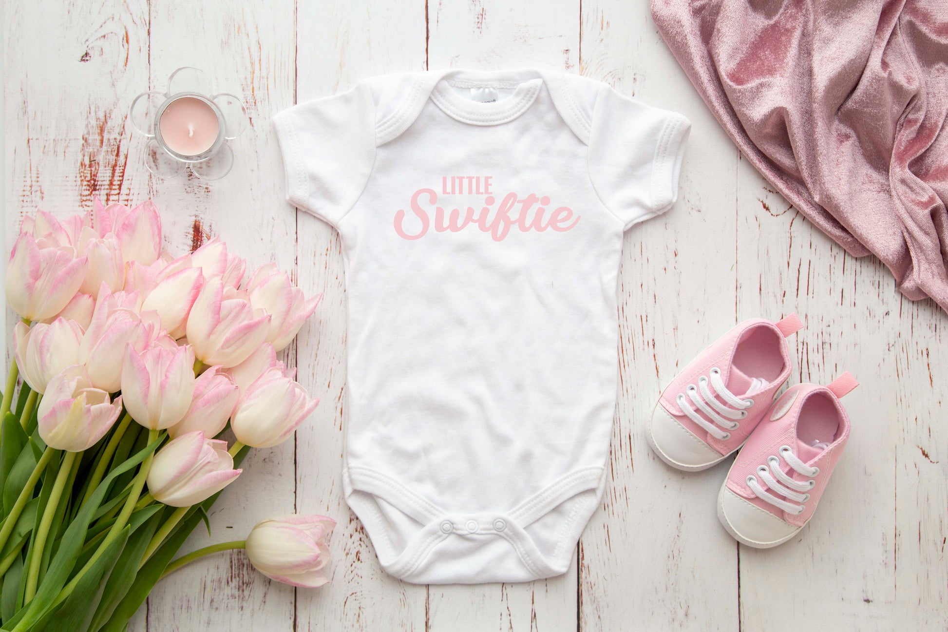 Little Swiftie pastel pink text on a white baby onesie