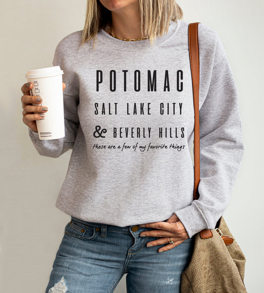 Woman wearing a heather grey sweatshirt that reads “Potomac, Salt Lake City & Beverly Hills – these are a few of my favorite things,” blending Real Housewives fandom with a nod to The Sound of Music.